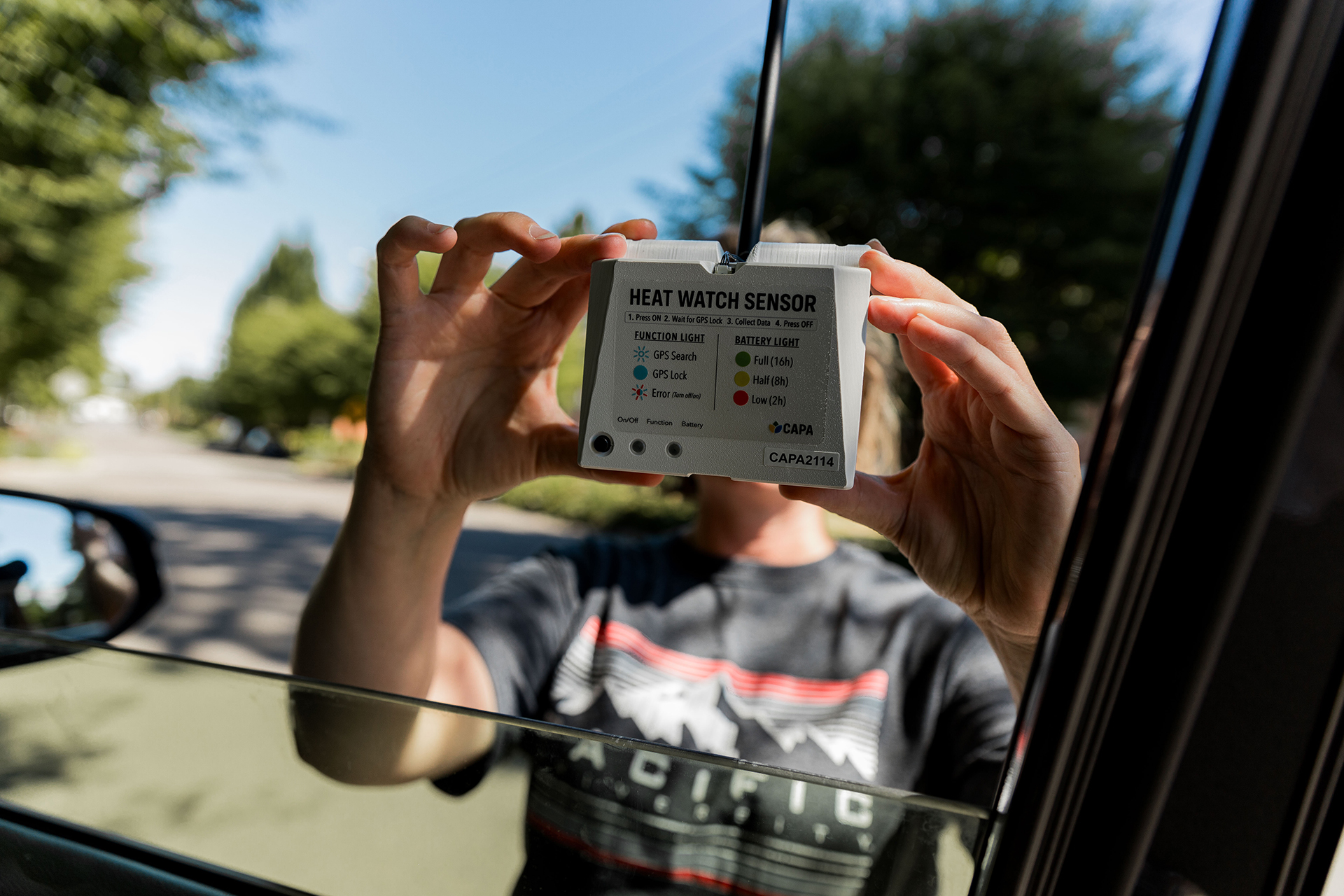Public health student Kylie Hepler '25 attaches a heat sensor to her car
