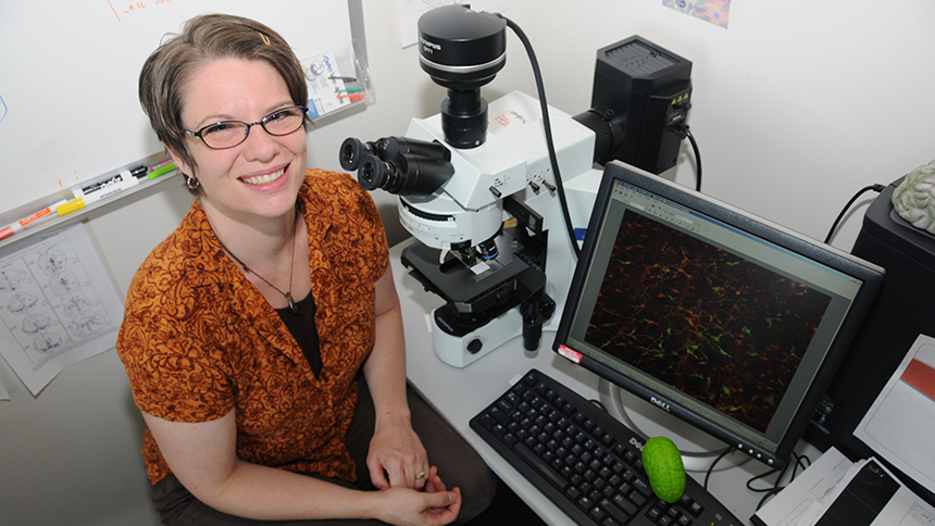 Amber Buhler with microscope and computer, from a Pacific file photo