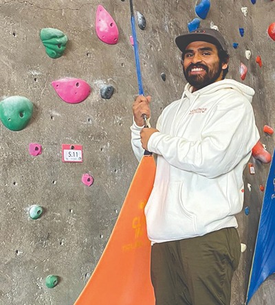 Wesley Heredia In Front Of Rock Climbing Wall