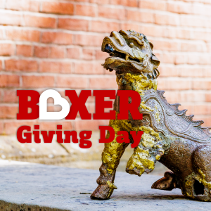 Boxer Giving Day Logo Boxer statue against a brick background