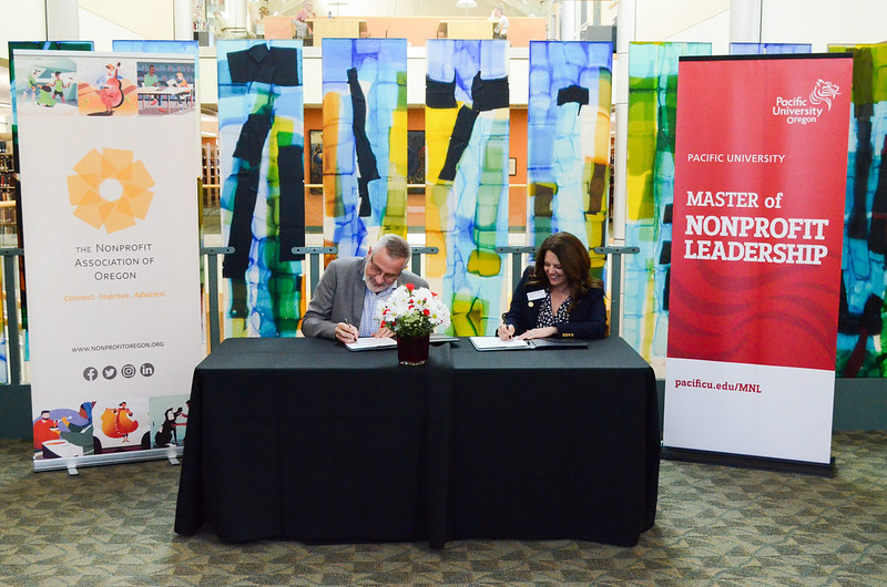 Nonprofit Association of Oregon Executive Director Jim White and Pacific University President Jenny Coyle sign a partnership agreement at a celebration at Pacific