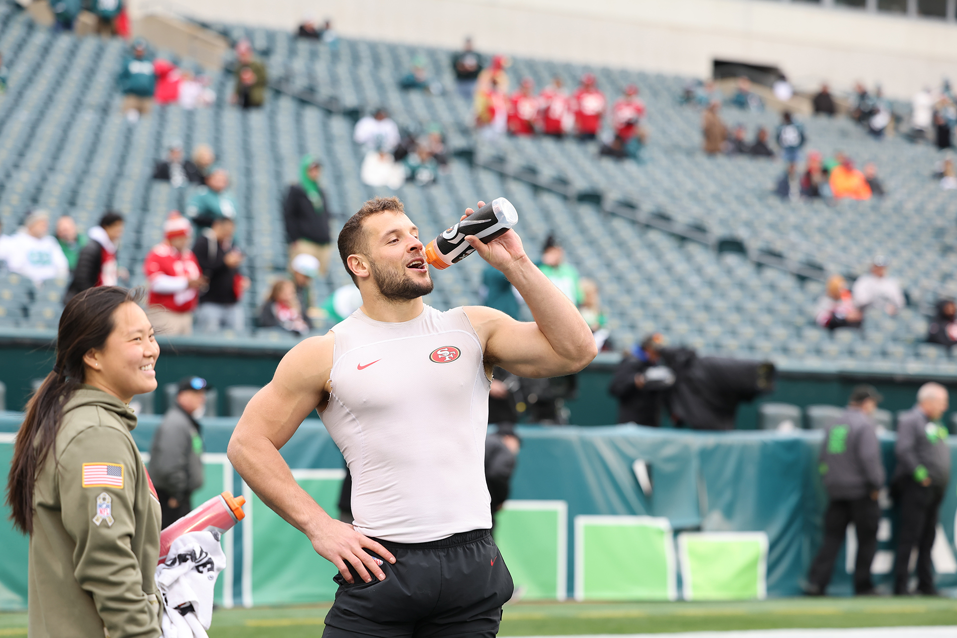 Oahn Ngo MSAT '22 laughs with a 49ers player on the sidelines