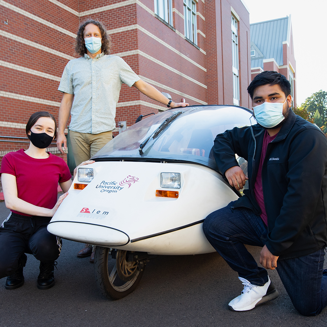 Shannon Gallagher ’21, Professor Andy Dawes, and Enrique Casas Cofraida ’23 with the electric car