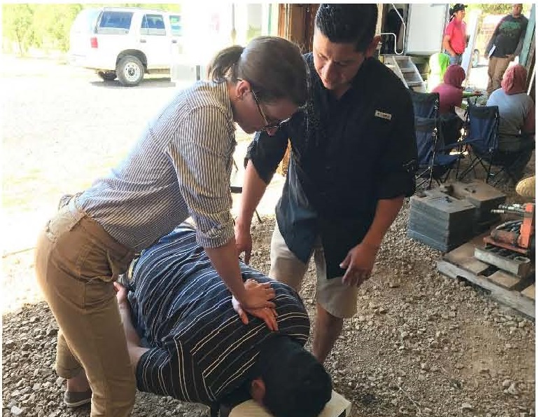 Jose Reyna supervises student performing physical therapy technique
