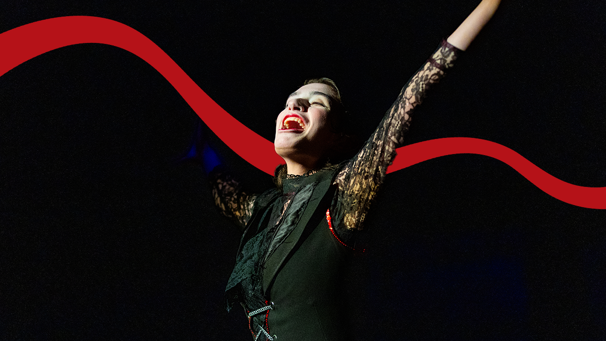 A Pacific student lifts their arms over their head on stage while performing Cabaret