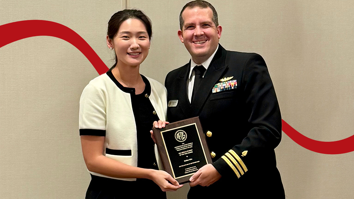 Pacific student Esther Kim OD '26 receives an award plaque from a man in military uniform.