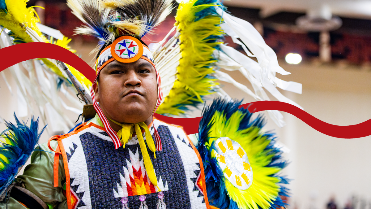 A powwow participant poses in full regalia