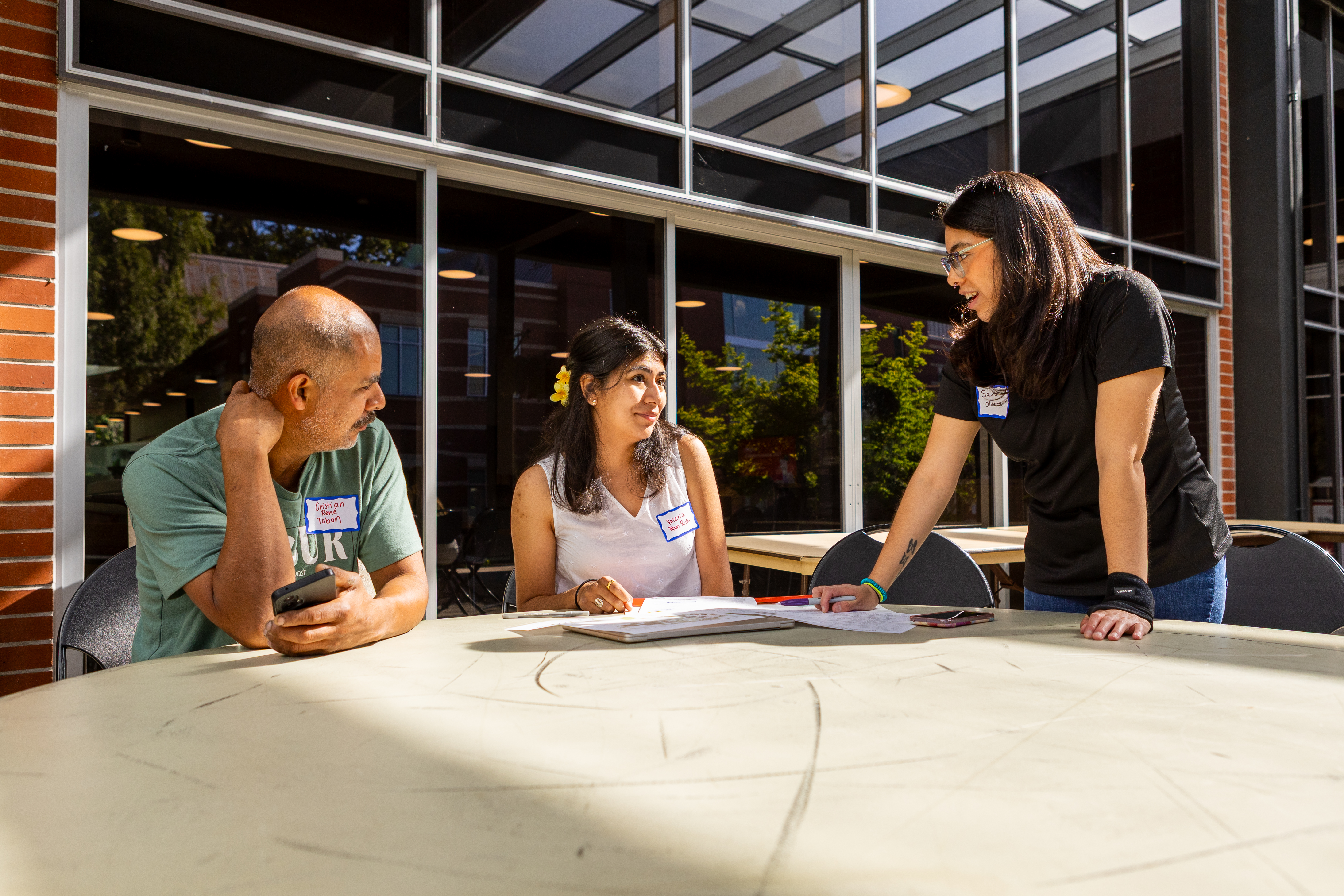 Pacific University students and advisors meeting at a table outside a campus building