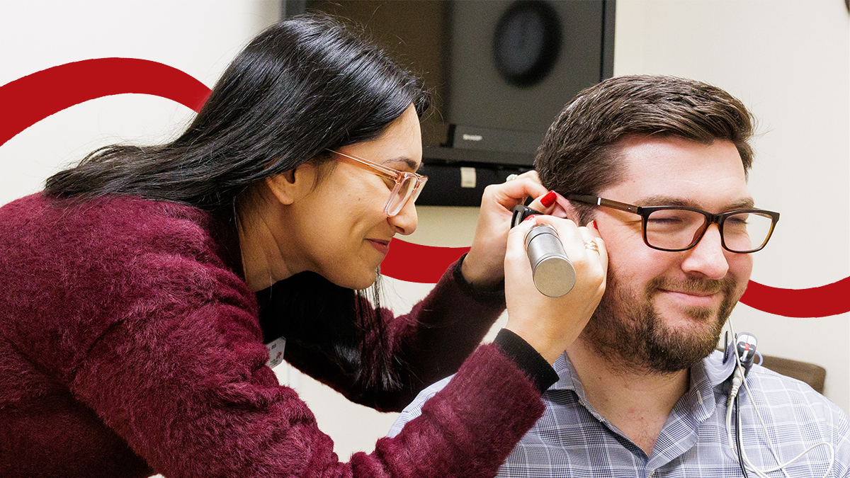A Pacific audiology student practices an exam in the EarClinic