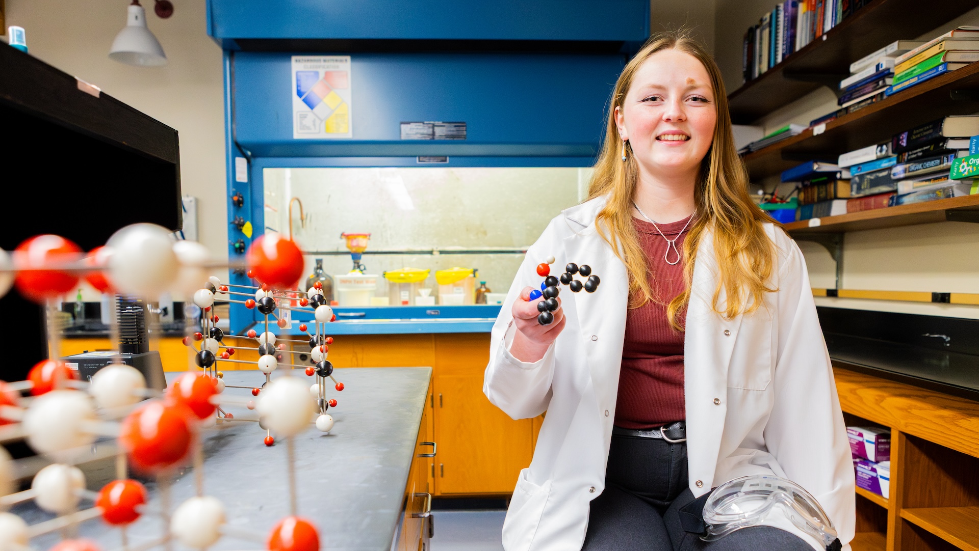 Female student in white lab coat in chemistry lab