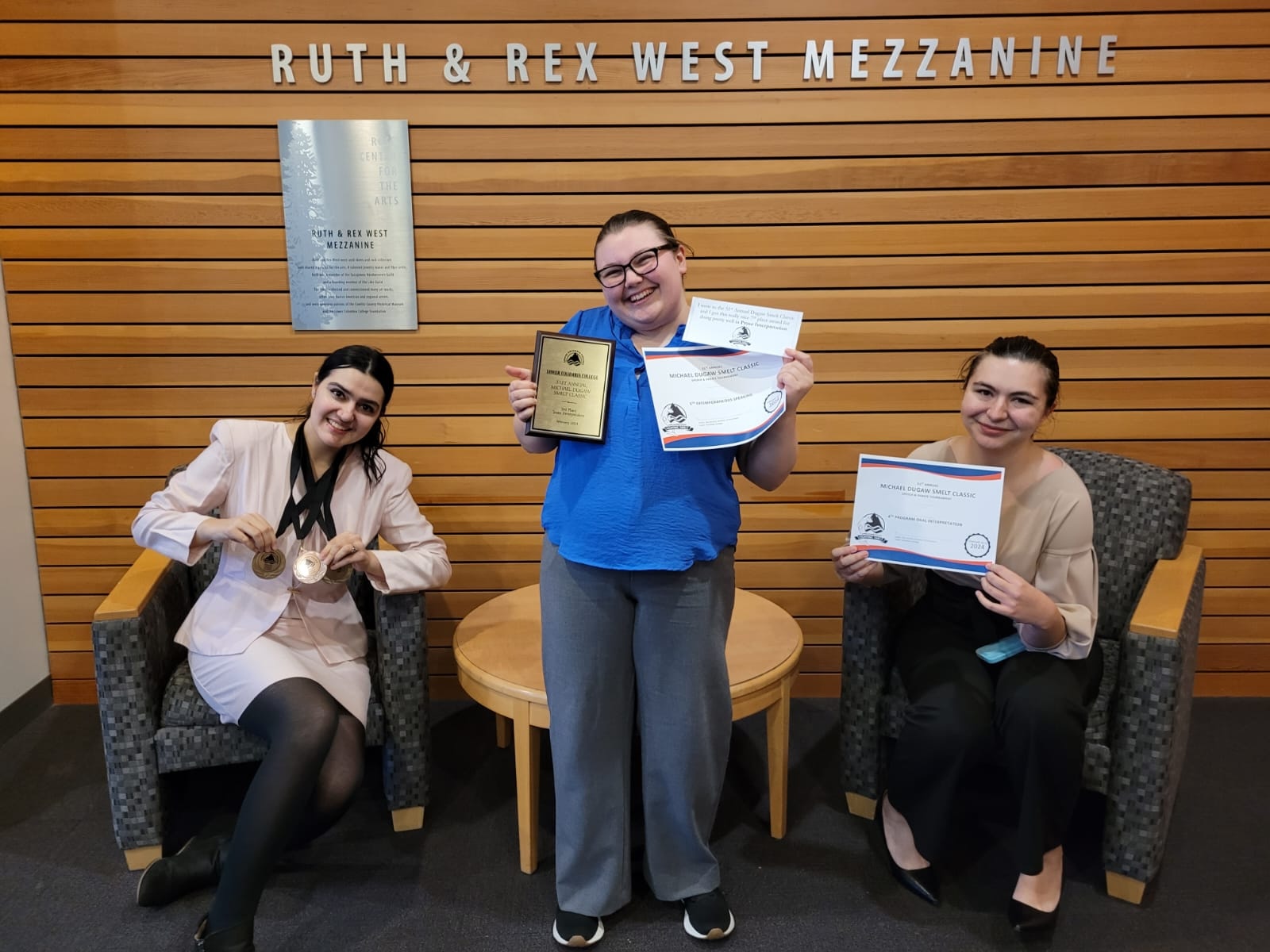 Three Pacific University debate students show off their awards