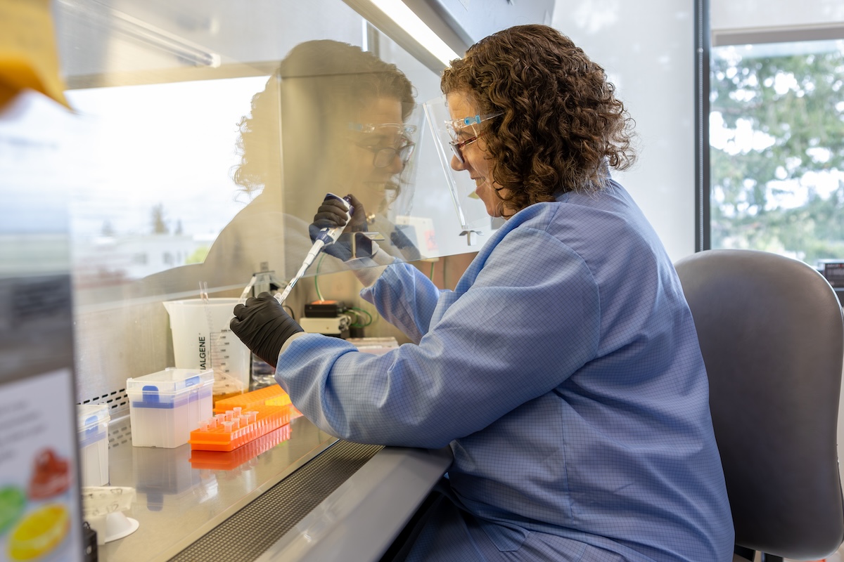 A pharmacy student works in the lab and dispenses chemicals via a pipet.