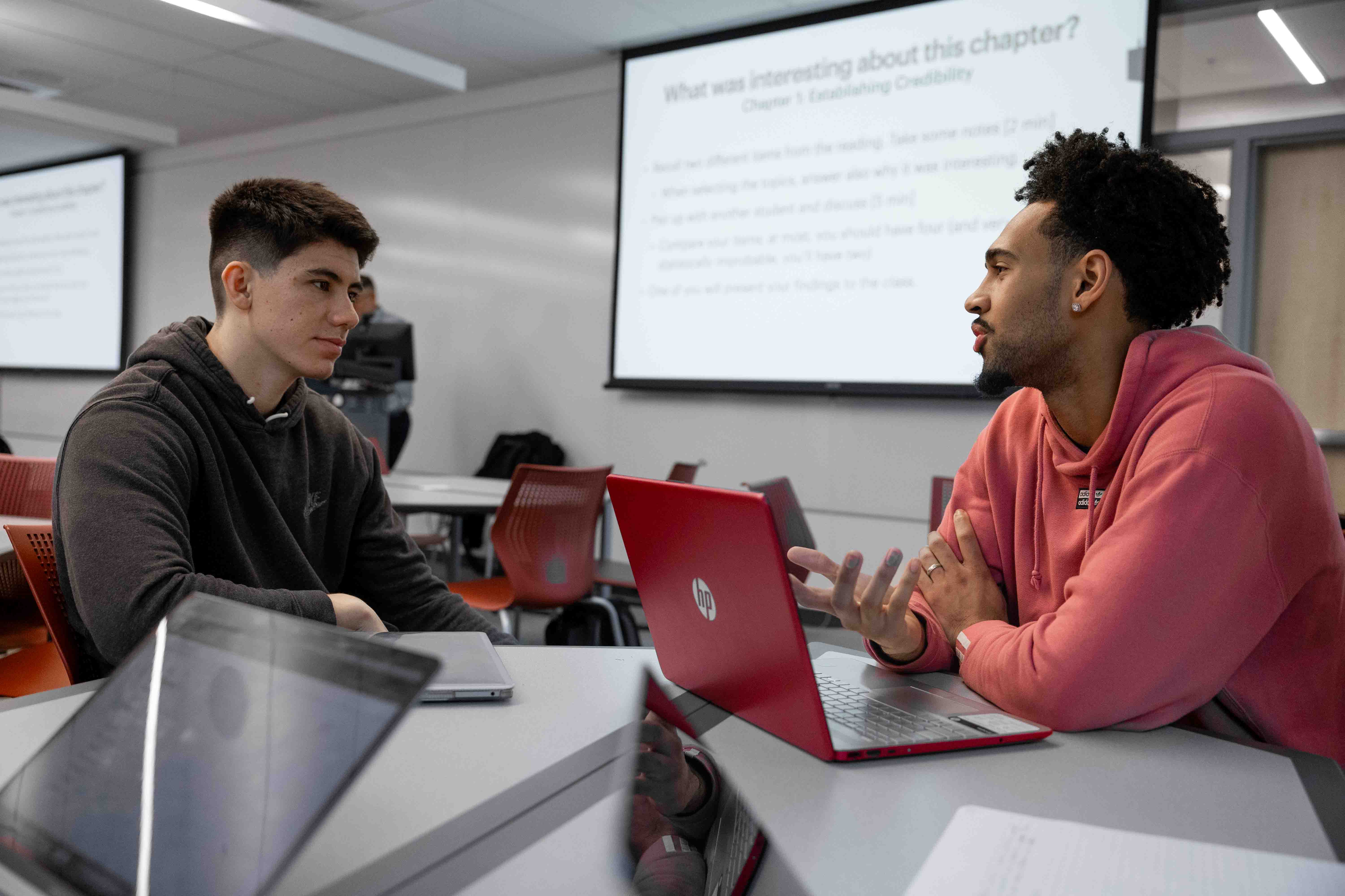 Two students discuss a question during class.