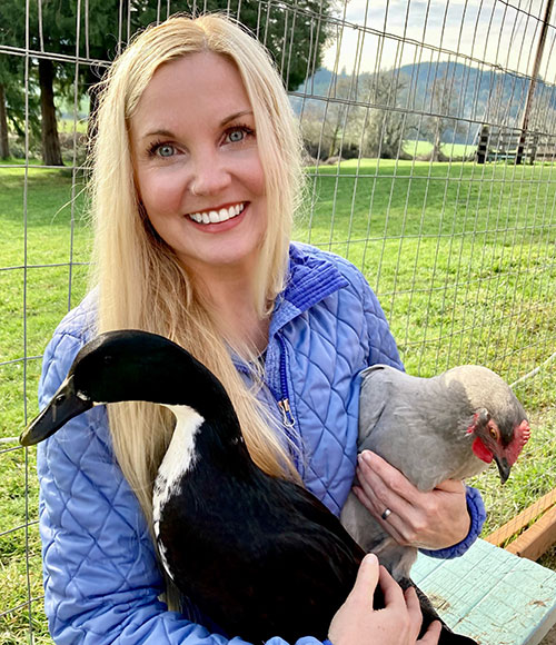 Pacific University Psychology Professor Heide Island Holding A Chicken and A Duck