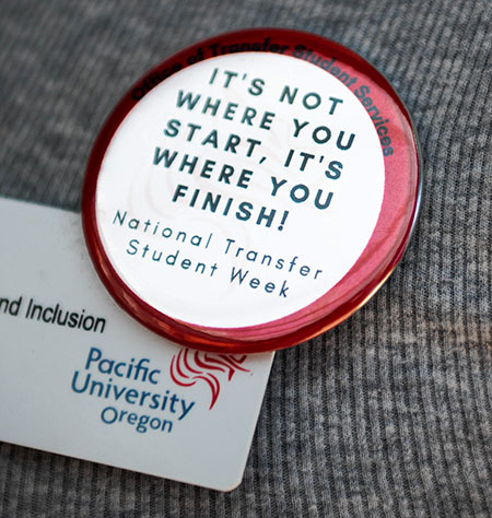 Button that reads "It's Not Where You Start, It's Where You FInish!" pinned to a person's shirt. Button is white with a red rim.