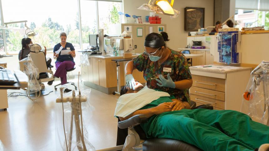 Dental hygienist with patient in dental clinic