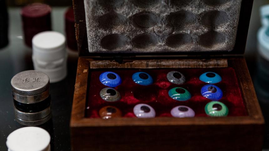 exhibit from the Contact lens Museum showing colored lenses in a red velvet lined box