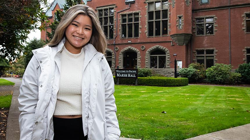 Annie Ho poses in front of Marsh Hall on the Pacific University Forest Grove Campus