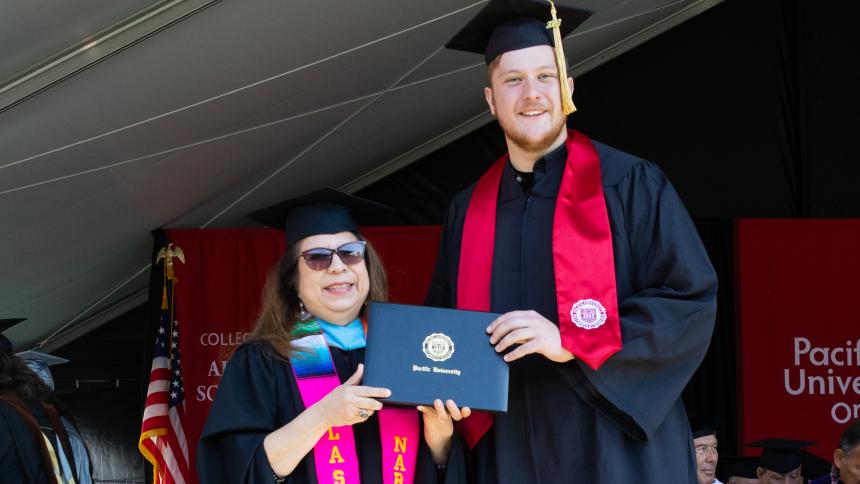 Mitchell Ulrich '22 receives a Pacific University diploma with Narce Rodriguez