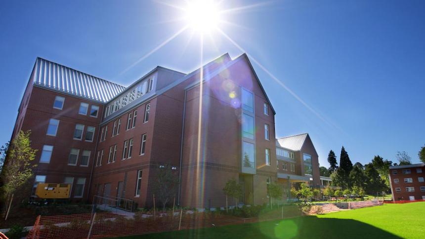 Photo of Cascade Hall with the sun shining above it