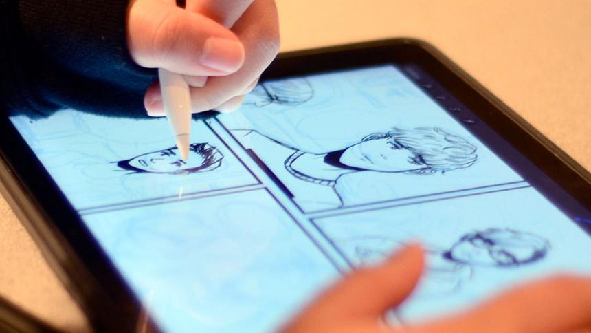 Student illustrating a digital comic book on an iPad 