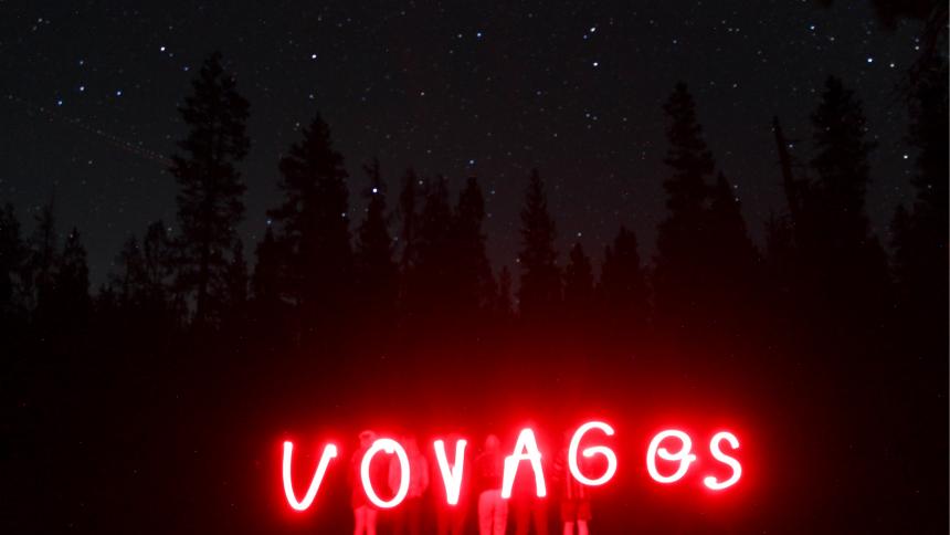 Students line up and spell out Voyages using a red light on their Backpacking Trip summer 2022