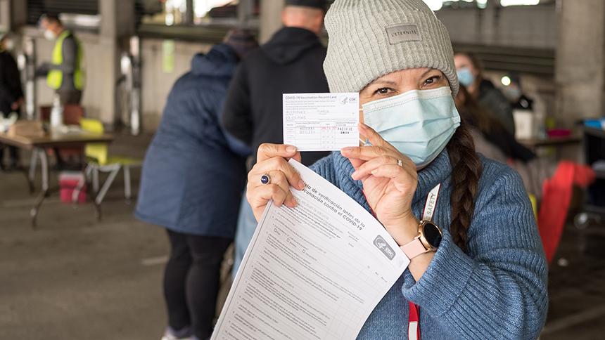 Pacific Employee Holds Up Vaccination Card at Early 2021 Clinic
