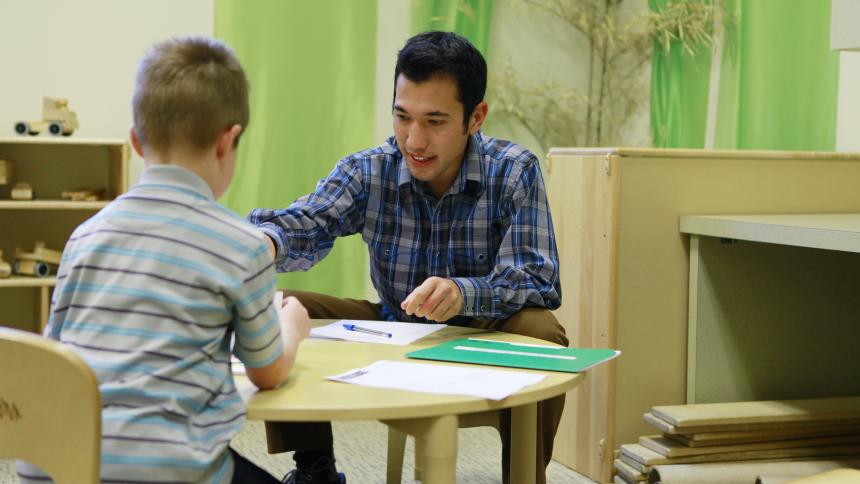 A speech-language pathology student works with a young child in a pediatric clinical setting. 