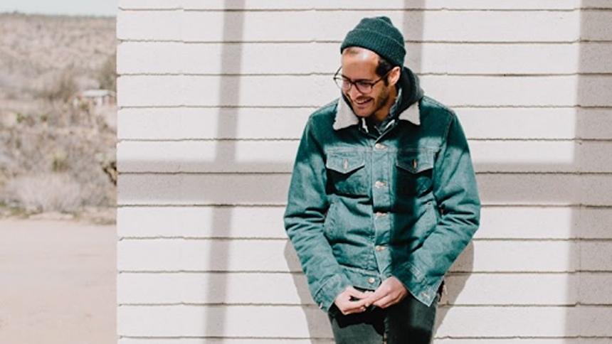 Anis Mojgani Leaning Against Wall, Wearing Winter Coat