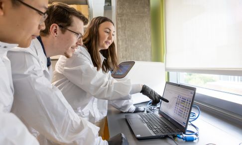 three Pacific University pharmacy students looking at a laptop in lab