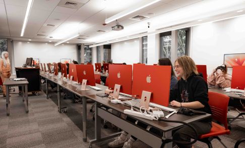 Pacific University students in computer lab with red desktops