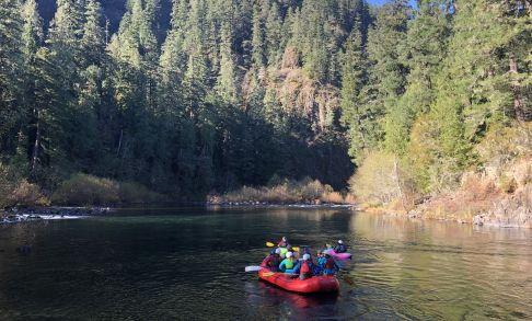 A group of students participate in the Outdoor Pursuits program by rafting down an Oregon river.