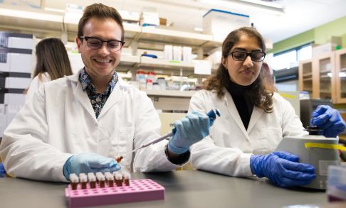 Two pharmacy students practice dispensing chemicals in the pharmacy lab.