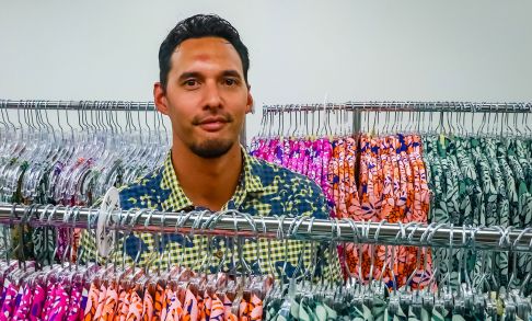 Lokahi Lunn '11 Standing In Between Two Racks Of Hawaiian Print Shirts