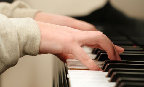 Closeup of two hands playing a piano.
