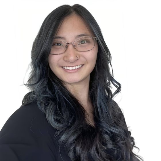 Headshot of Melissa Gabel, She Chinese. Her hair is dark brown with blue highlights. She is smiling and wearing glasses and black shirt with a white background.