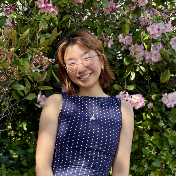 Yoorim stands in front of flowers.
