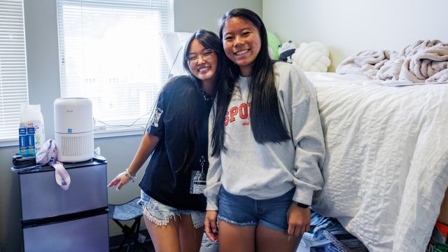 Roommates pose in a residence hall at Pacific University