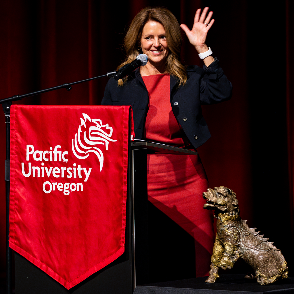 Jenny Coyle and the original Boxer statue on stage with a podium 