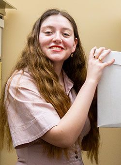 Elle Griego '26 posing with an archive box inside the Pacific University Archives.