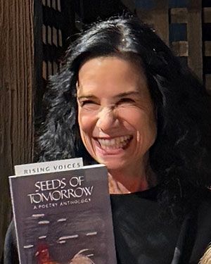 Nancy Miller Gomez MFA '17 holding a book
