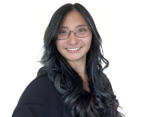Headshot of Melissa Gabel, She Chinese. Her hair is dark brown with blue highlights. She is smiling and wearing glasses and black shirt with a white background.