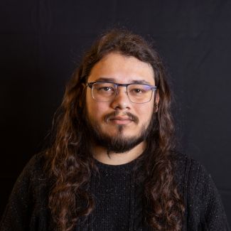 Portrait of Thomas Lal taken in front of a black background.
