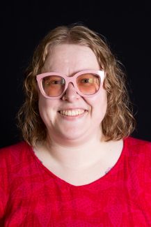 A photo of a Violet wearing a red shirt and large pink glasses.