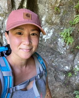 a woman wearing a ballcap and hiking backpack