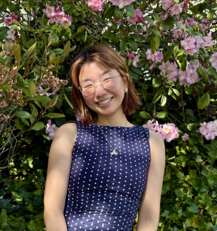 Yoorim stands in front of flowers.