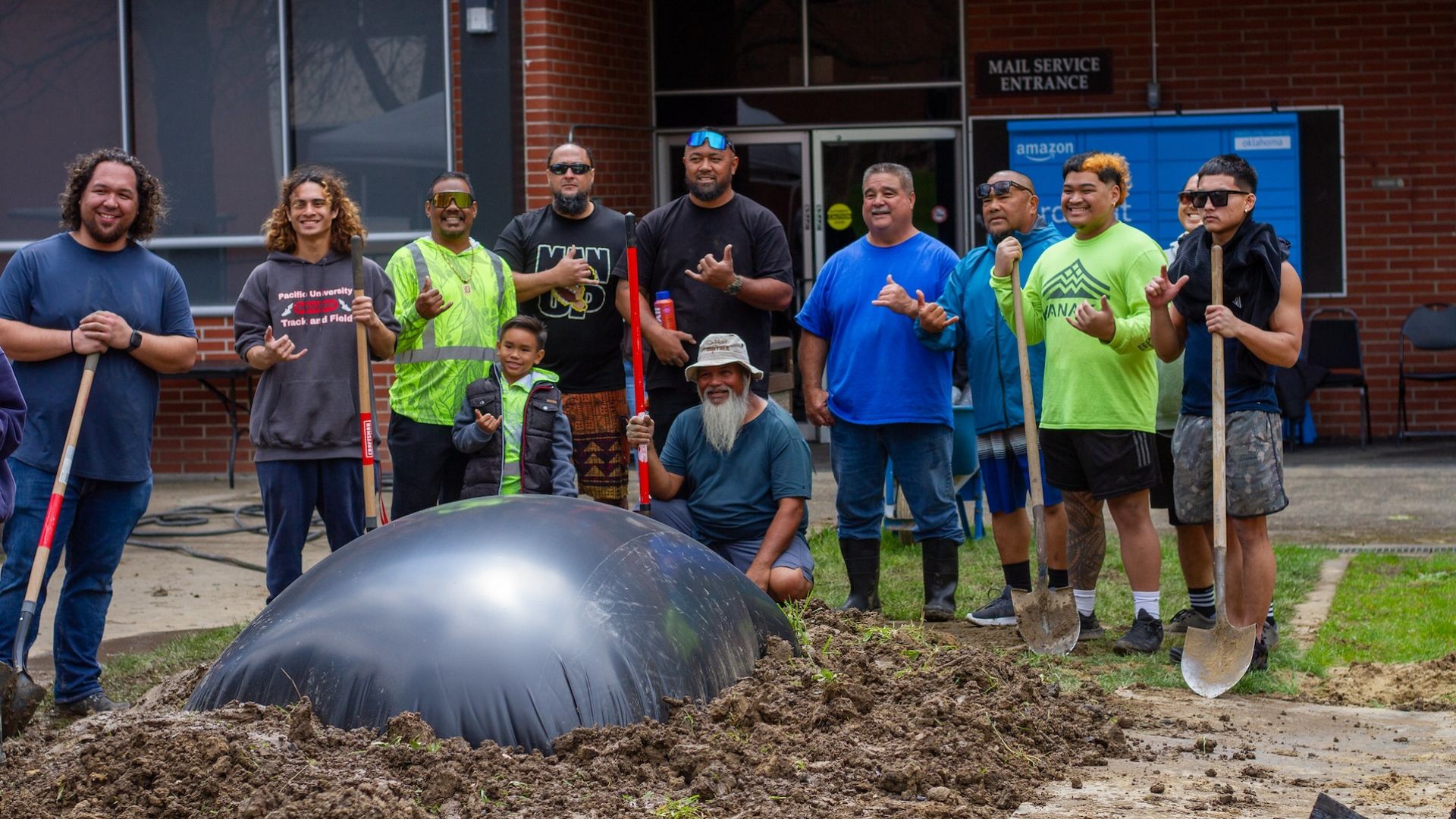 volunteers with shovels posing in front of a project