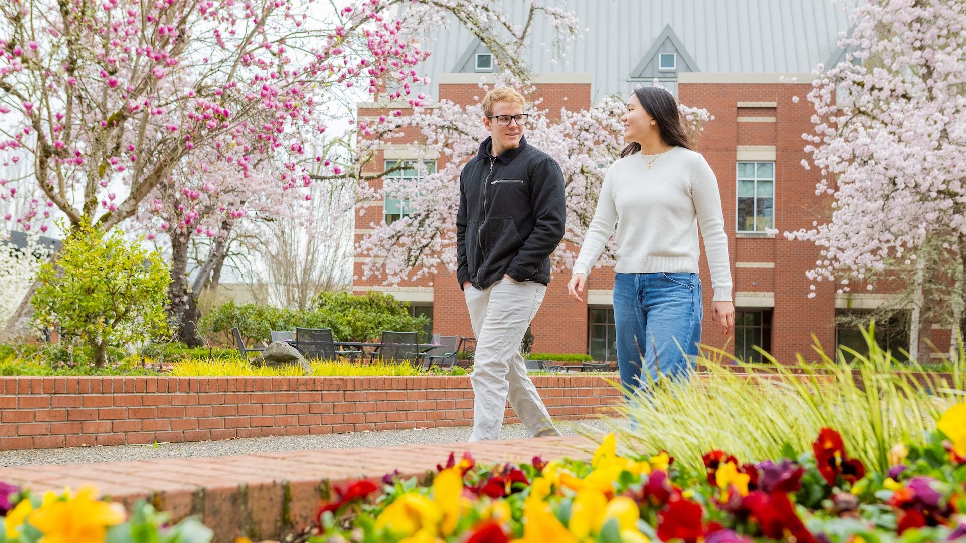 two students walking on campus in spring