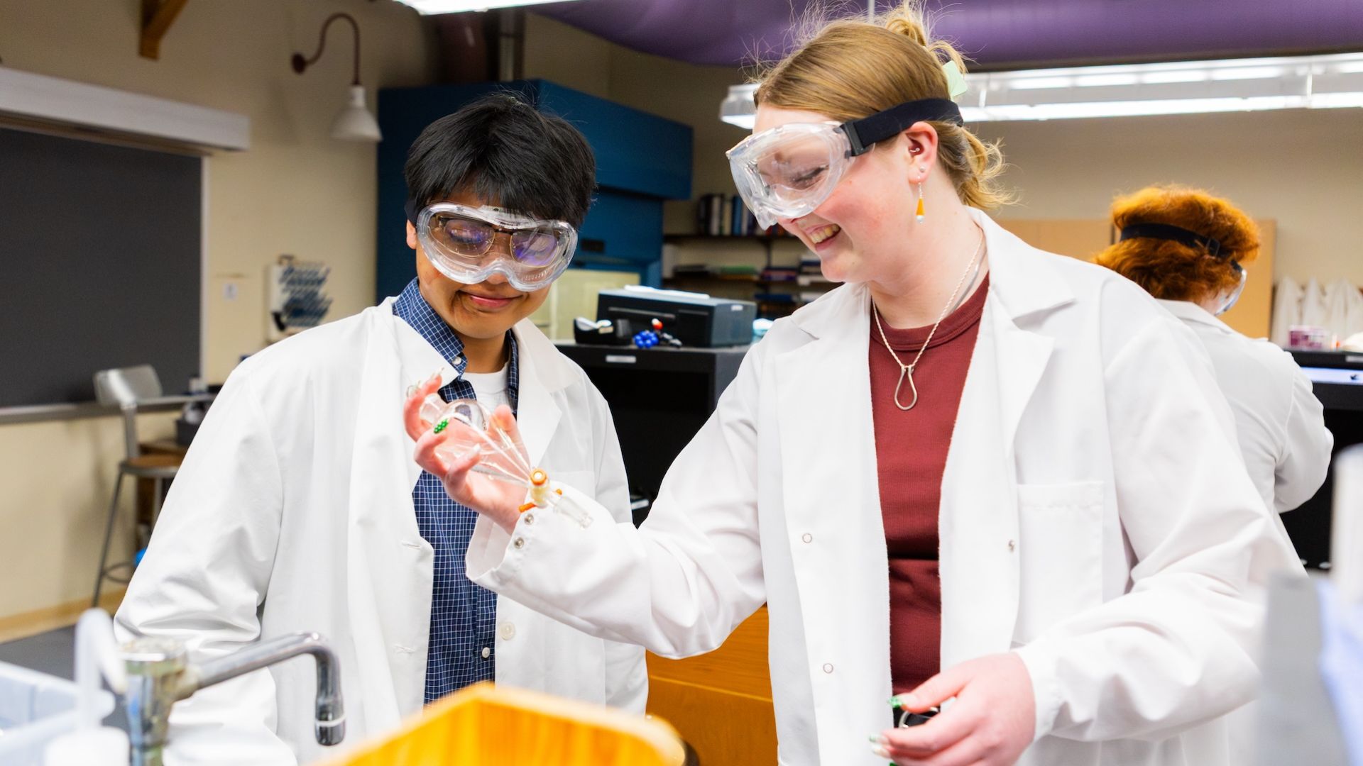 Chemistry students work on an experiment together in the lab.