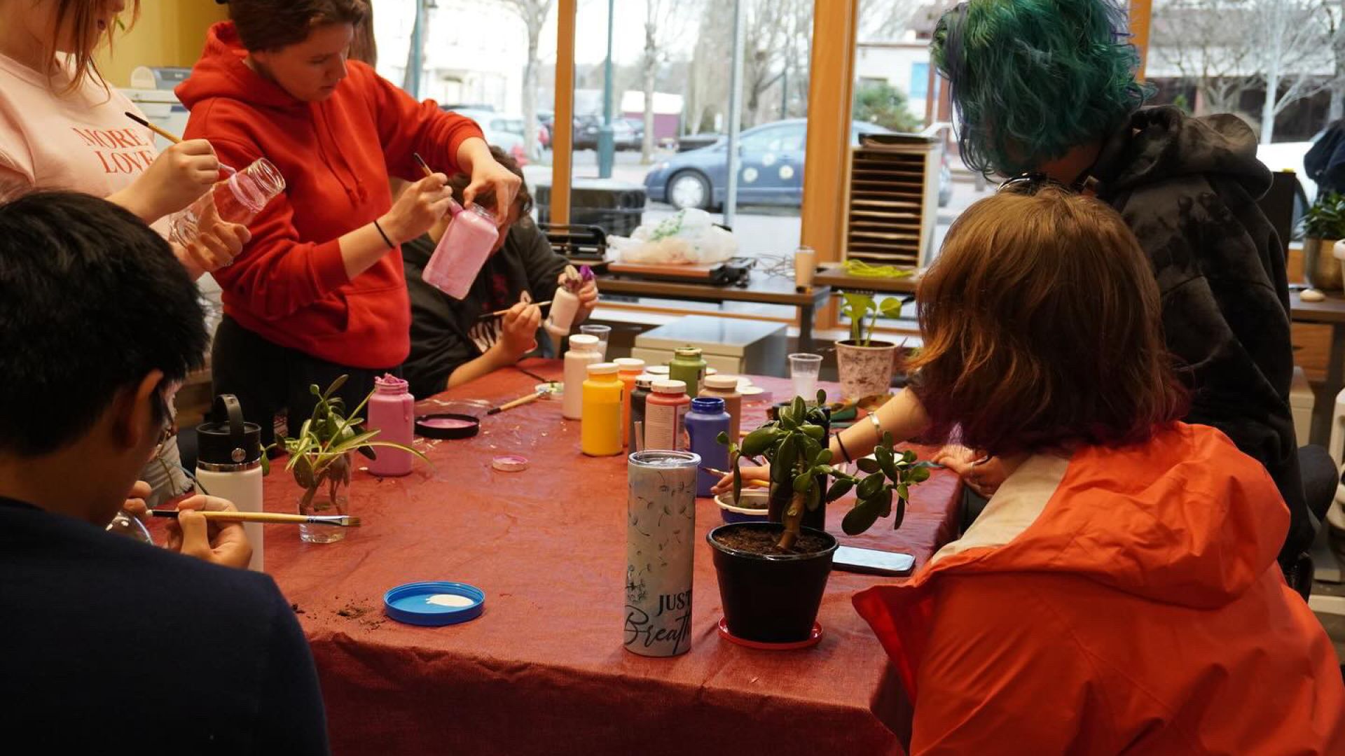 Students painting pots and planting plants. 
